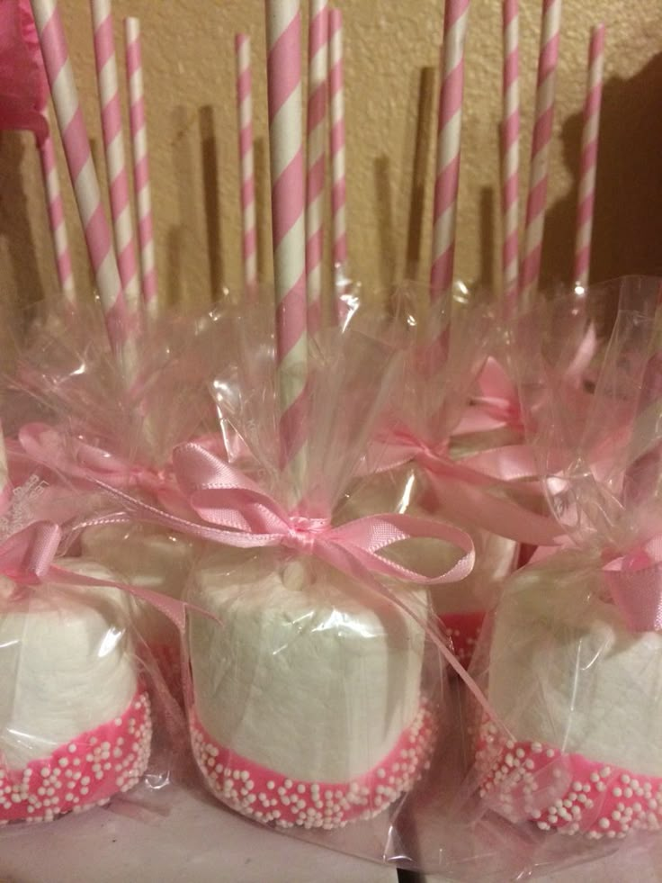 pink and white cupcakes wrapped in clear cellophane with candy canes