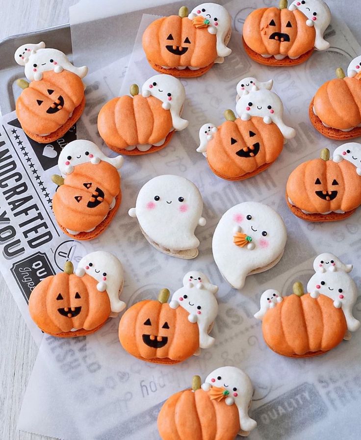 there are many decorated pumpkins and ghost cookies on the tray with white frosting