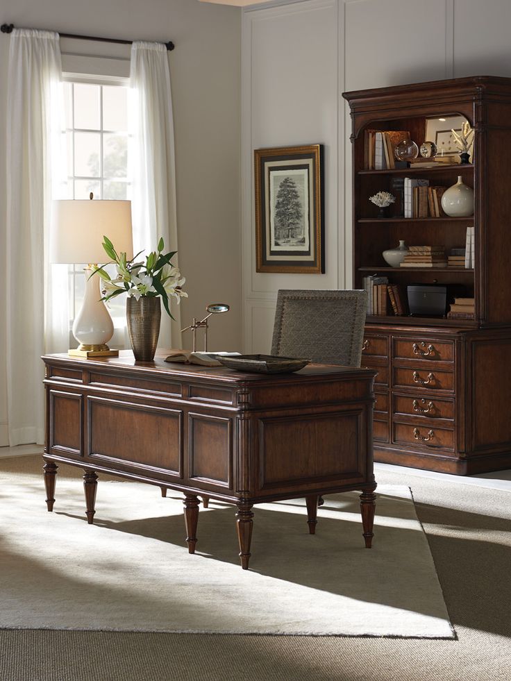 an office desk in front of a large window