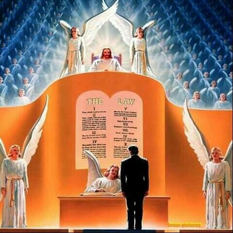 a man standing on top of a stage next to angels and the names of all saints