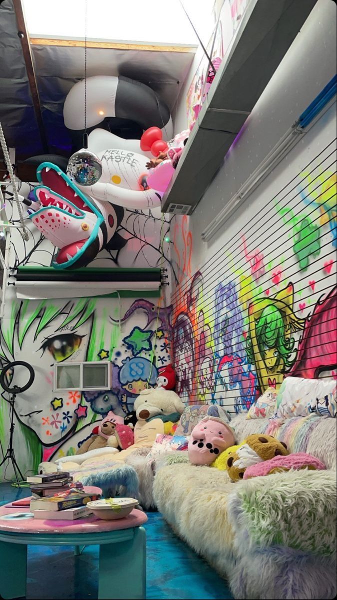 a room filled with lots of stuffed animals on top of pillows and rugs in front of graffiti covered walls