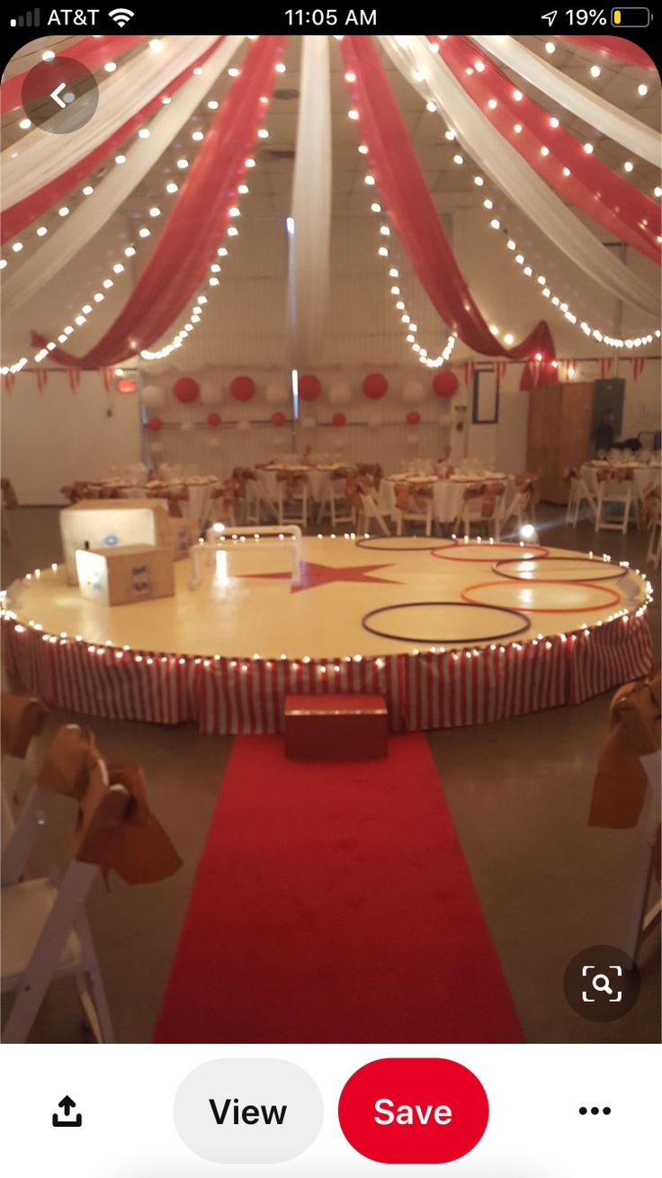 an indoor basketball court is decorated with red and white draping for the ceiling