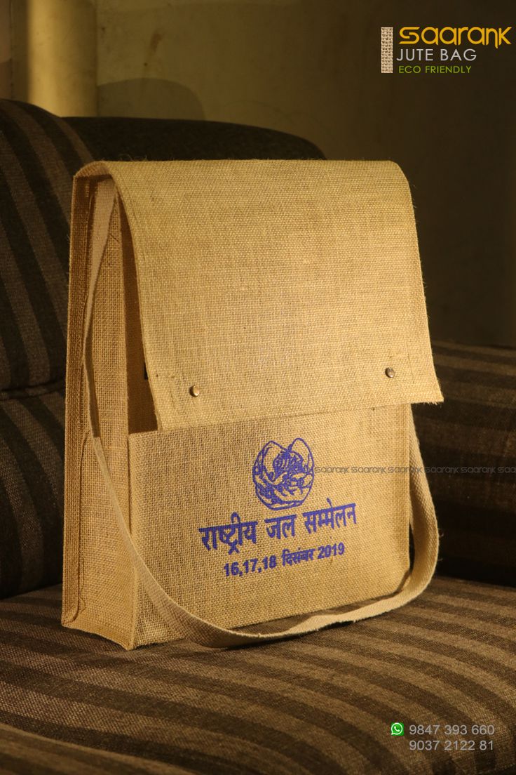 a bag sitting on top of a couch next to a striped chair with the word india written in blue