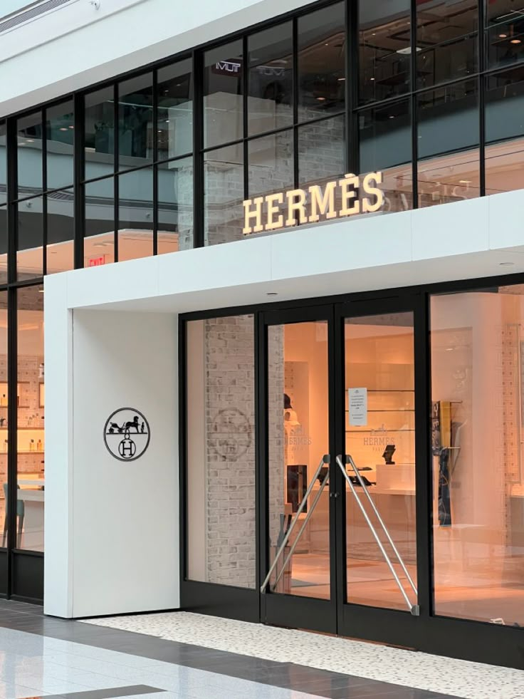 the entrance to a store with glass doors and windows that say hermes on it