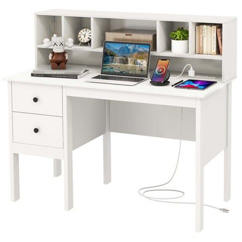 a white desk with a laptop and phone on it