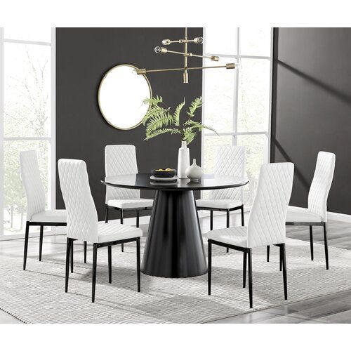 a dining room table with white chairs and a round black table in front of a large window