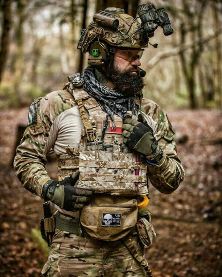 a man in camouflage gear standing in the woods