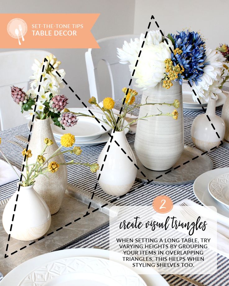 the table is set with white vases and flowers in them, along with other place settings