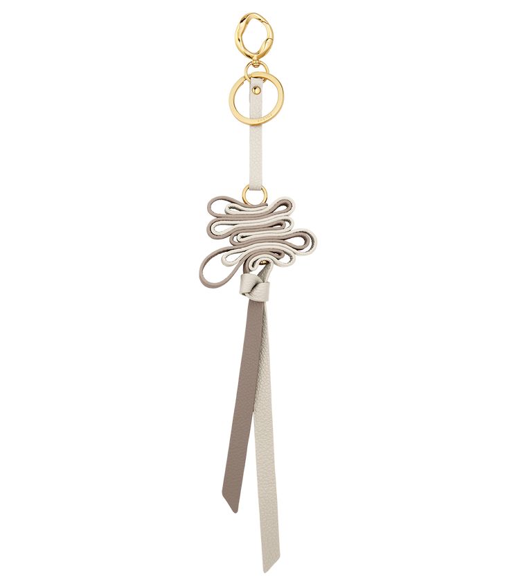 a white key chain with two rings and a tie on the end, hanging from it's side