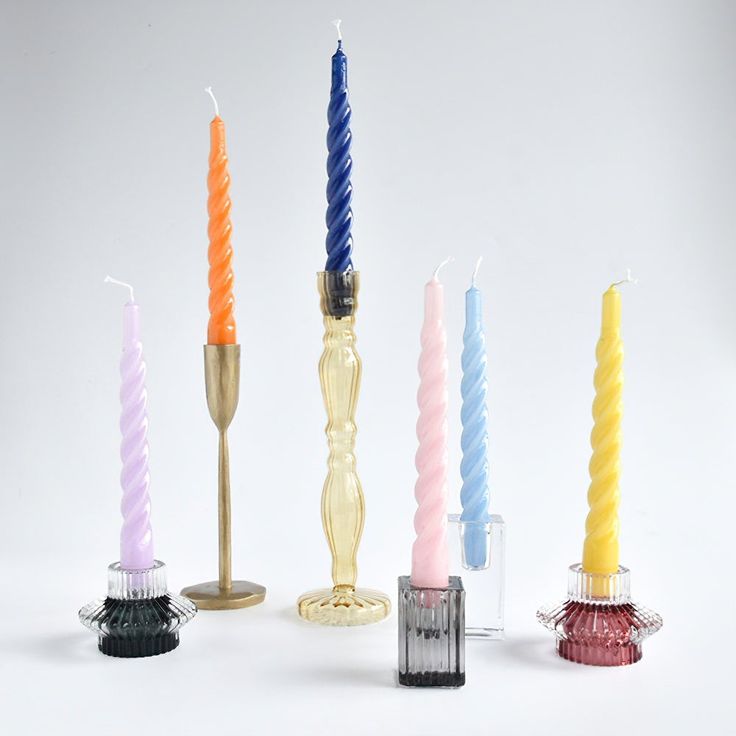 five candles in different colors are lined up next to each other