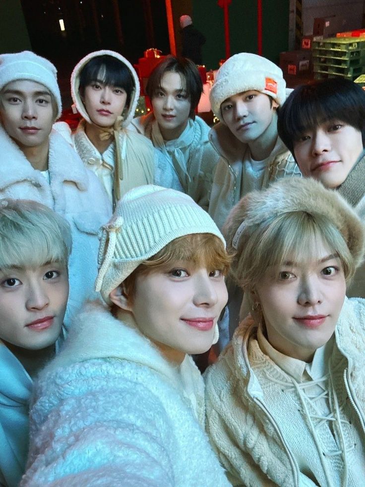 the group of young men are posing for a photo together in winter clothes and hats