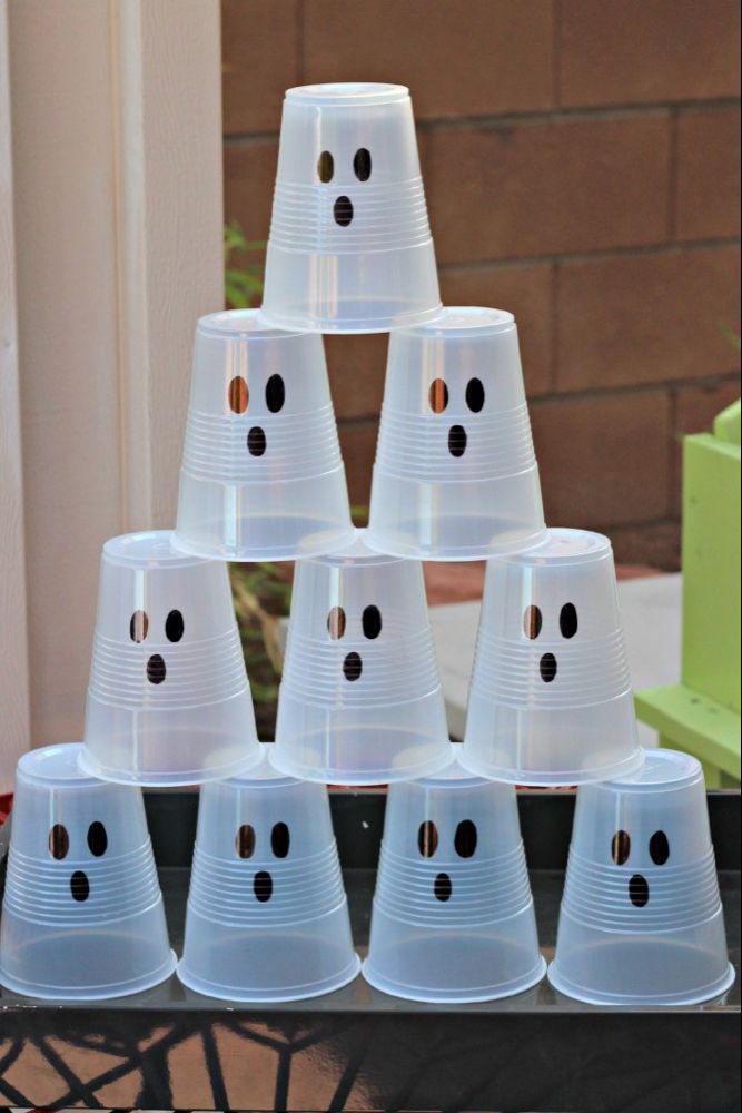 plastic cups with faces are stacked on top of each other in the shape of a pyramid