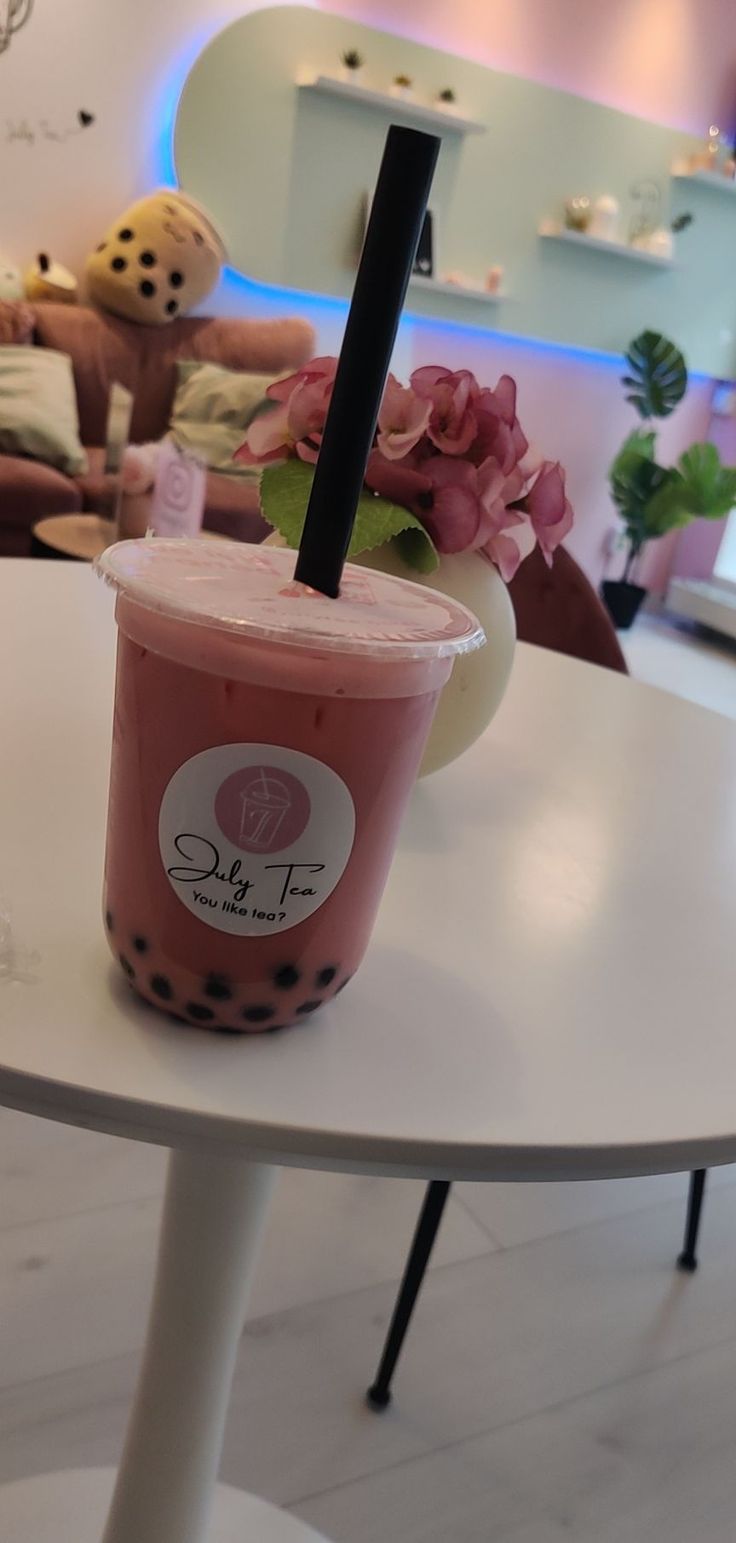 a pink drink sitting on top of a white table