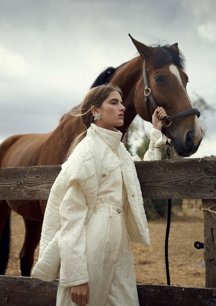 a woman standing next to a brown horse