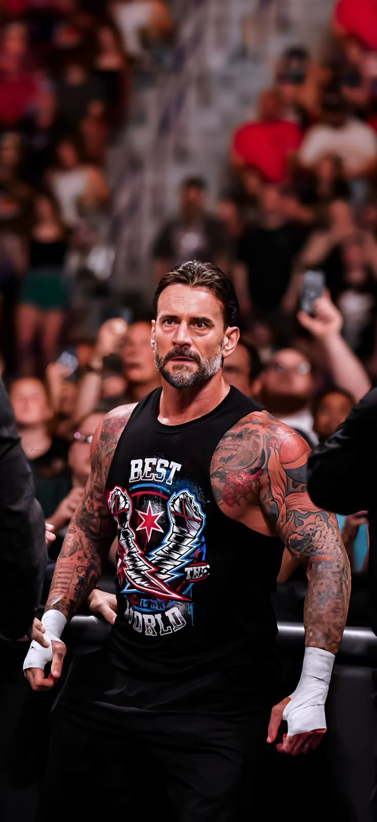 a man with tattoos standing in front of a crowd