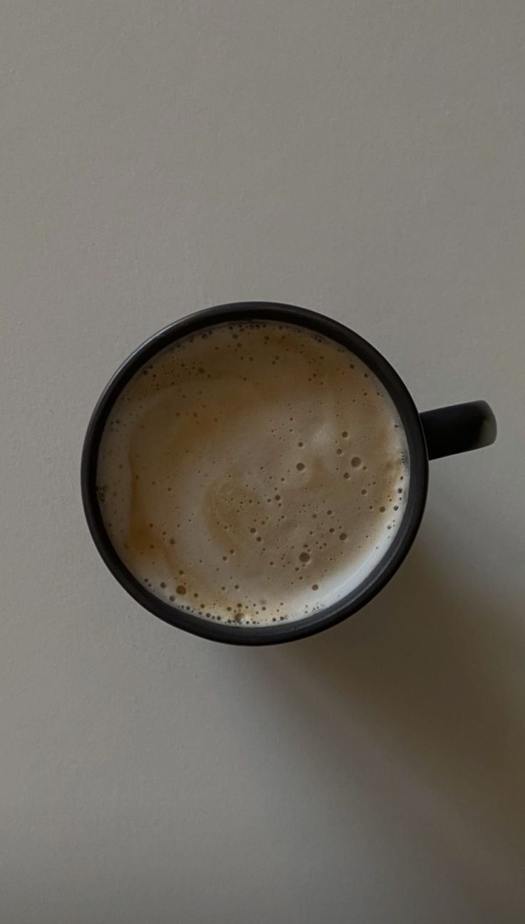 a cup of coffee sitting on top of a table