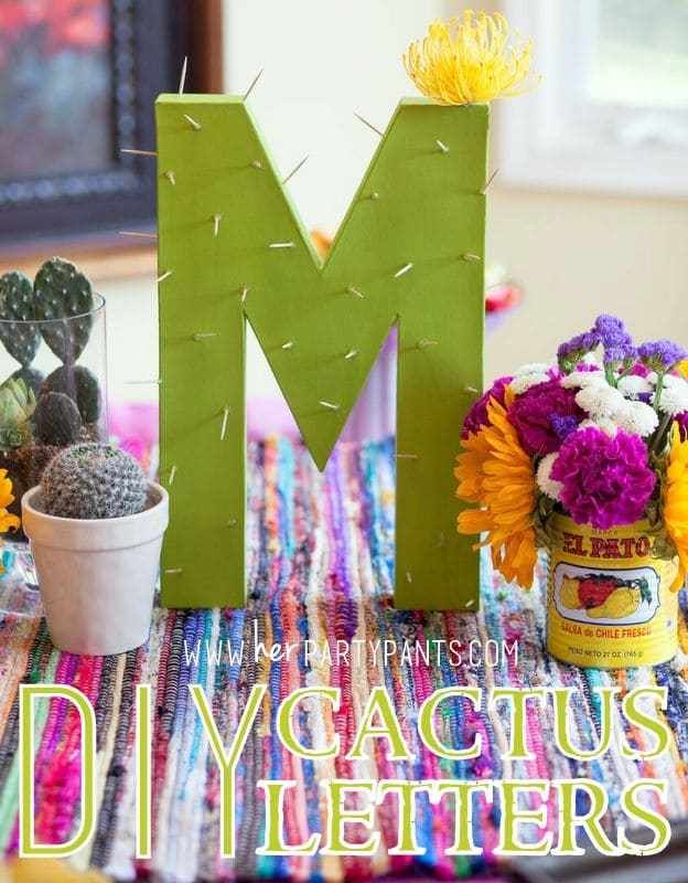 the letters m and m are made out of paper, with cactuses in front