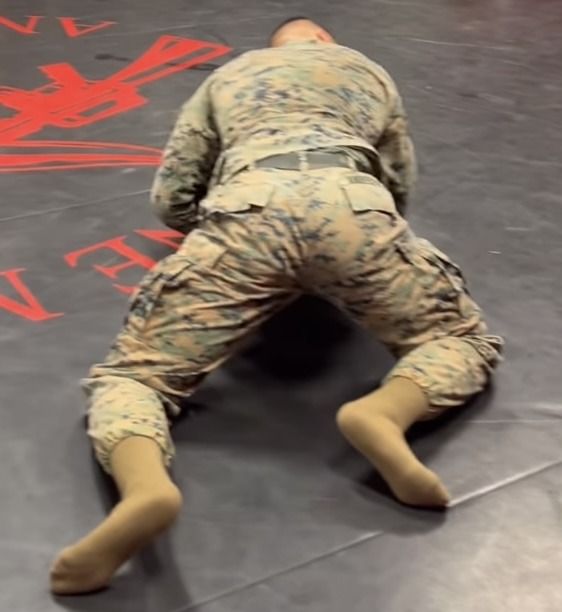 a man in uniform is laying on the ground with his legs spread out and head down