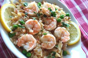 shrimp and rice with lemon wedges in a white bowl