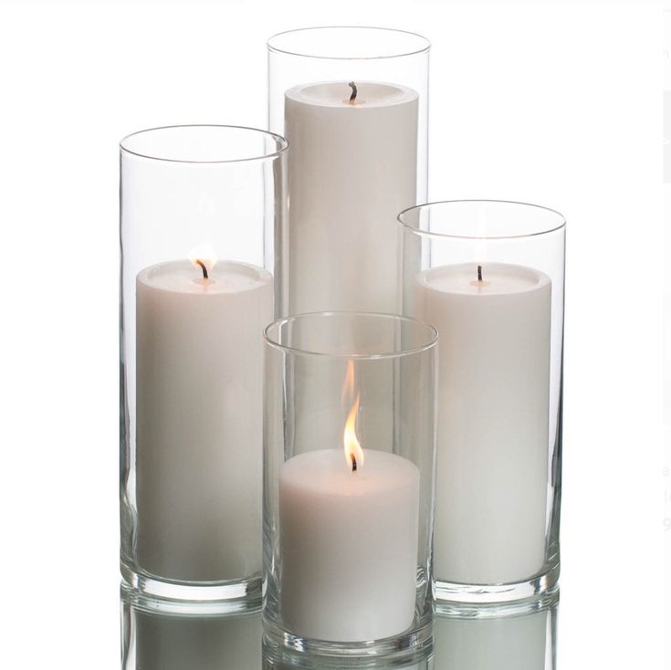 three white candles are sitting in glass vases