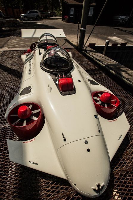 a white and red race car sitting on top of a metal grate covered ground