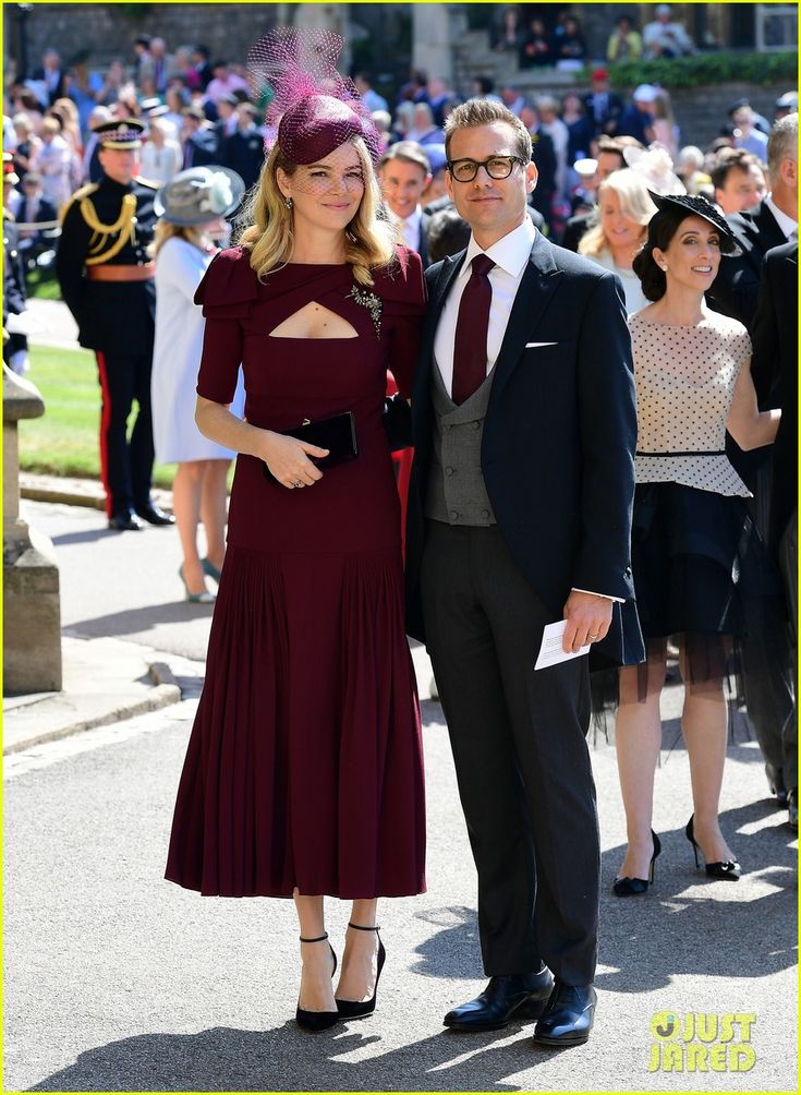 a man and woman standing next to each other in front of a large group of people