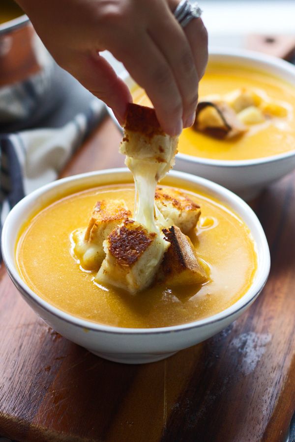 a person dipping something into a bowl of soup