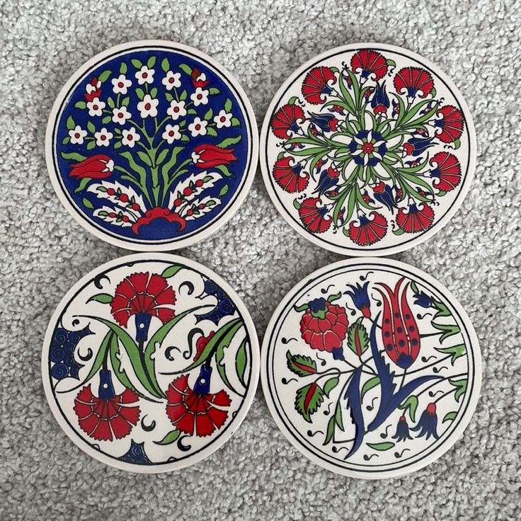 four plates with designs on them sitting on the floor