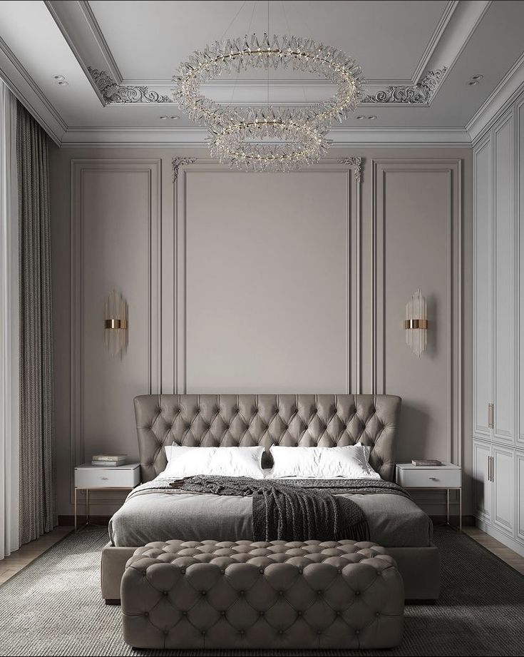 a large bed sitting in the middle of a bedroom next to a chandelier