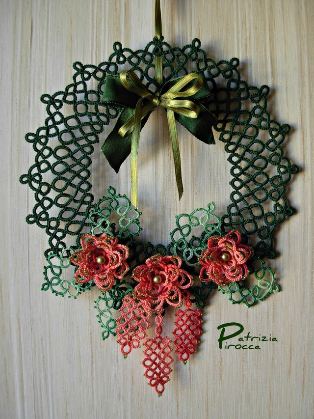 a green and red wreath with flowers on it