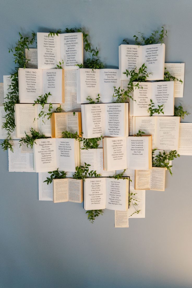 an arrangement of open books with greenery on them are arranged in the shape of a heart