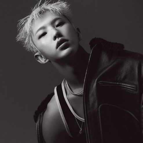 black and white photograph of a young man with blonde hair wearing a leather jacket looking up at the sky