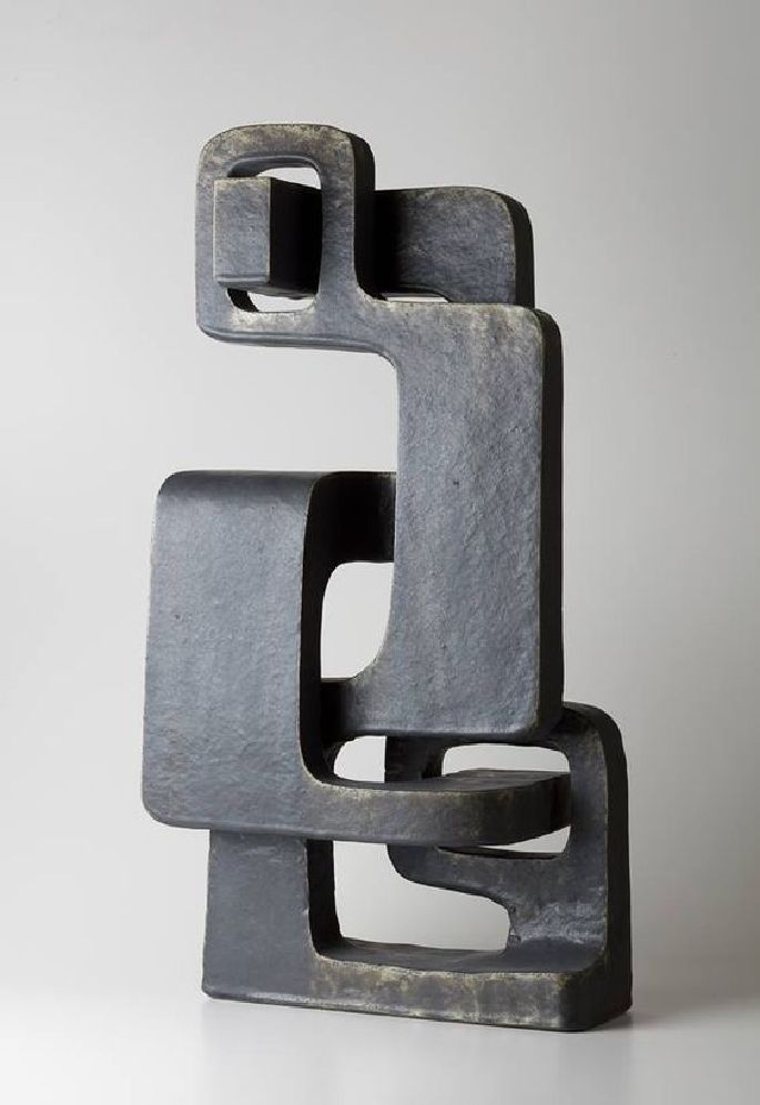 an abstract sculpture made out of metal on a white surface