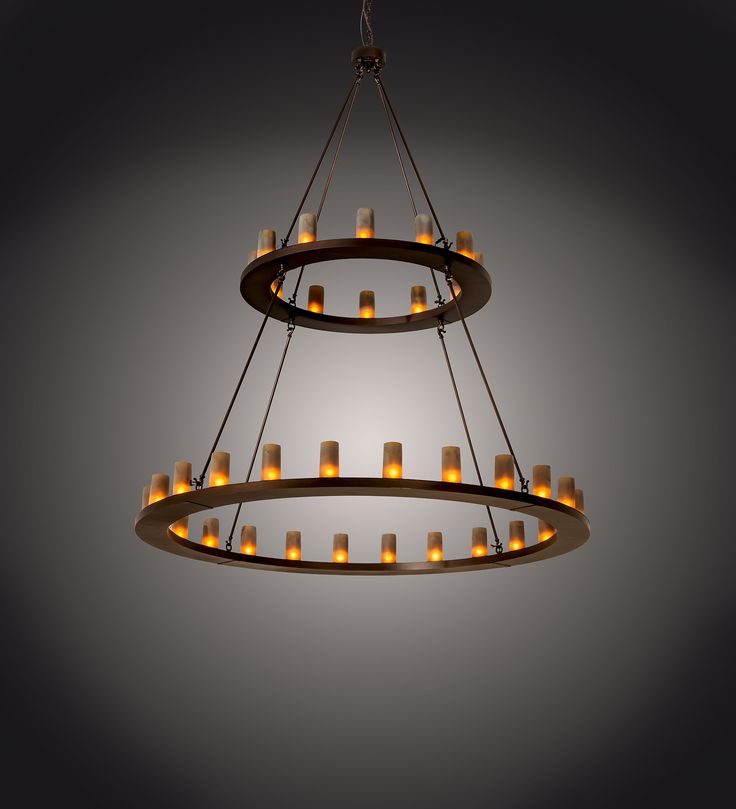 a circular chandelier with candles hanging from it's sides in an empty room