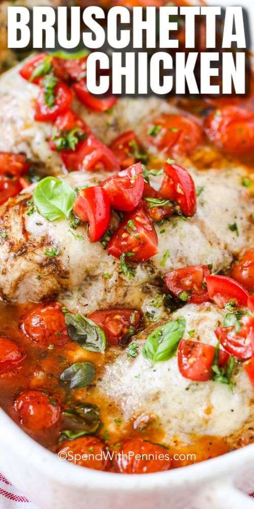 chicken with tomatoes and basil in a white casserole dish on a red checkered tablecloth