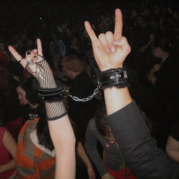 two people with their hands in the air at a concert