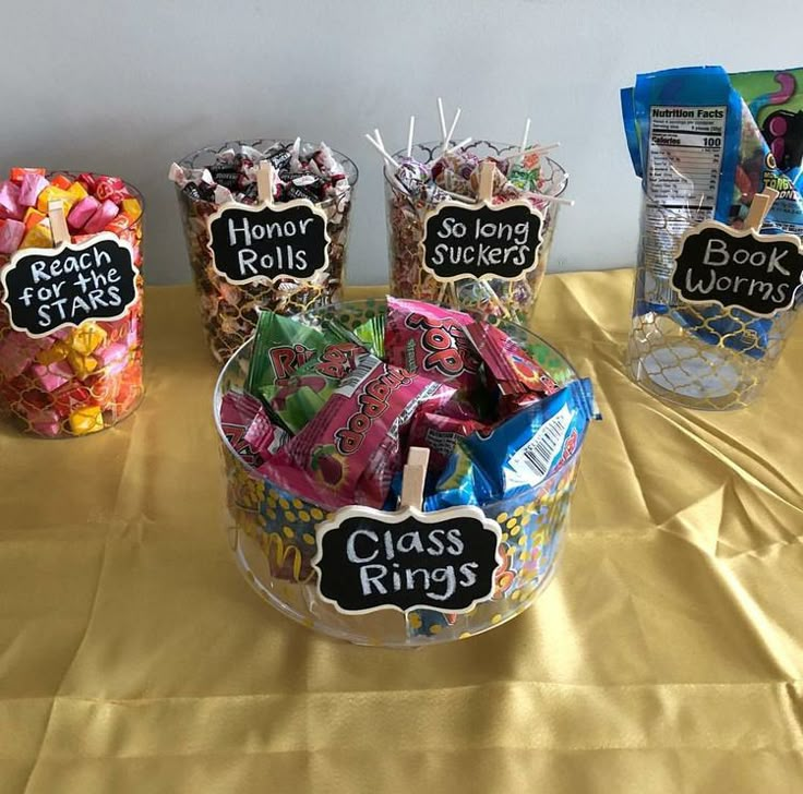 three baskets filled with candy on top of a yellow tablecloth covered table next to each other