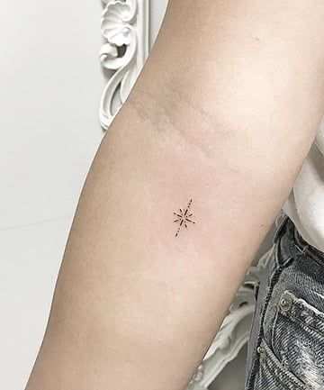 a woman's arm with a small star tattoo on the left side of her arm