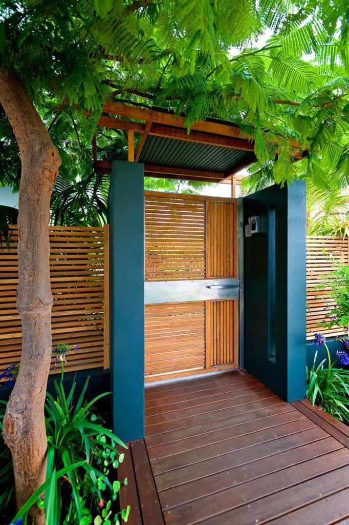 an outdoor shower is surrounded by plants and trees