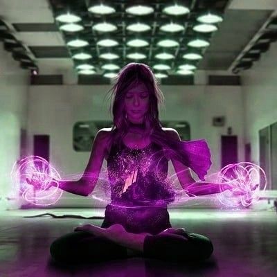 a woman sitting in the middle of a room with purple lights on her body and hands