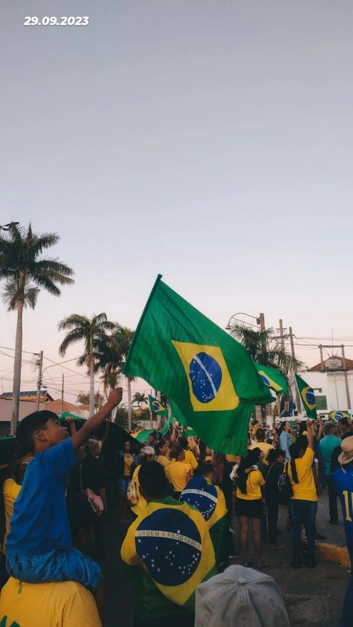 a group of people standing around each other holding flags and wearing blue and yellow shirts