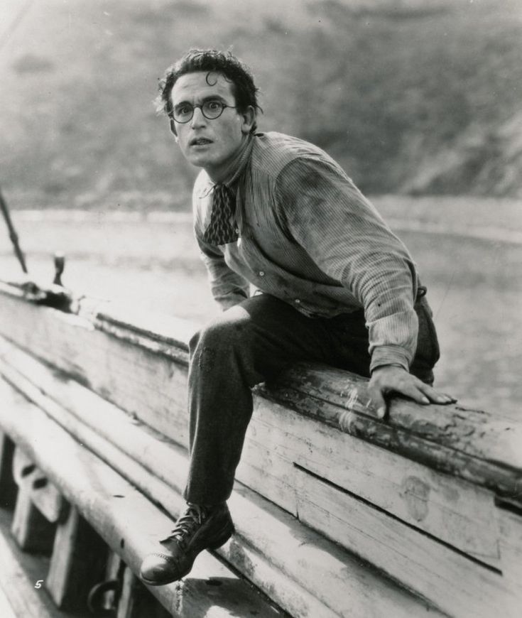 a man sitting on top of a wooden bench