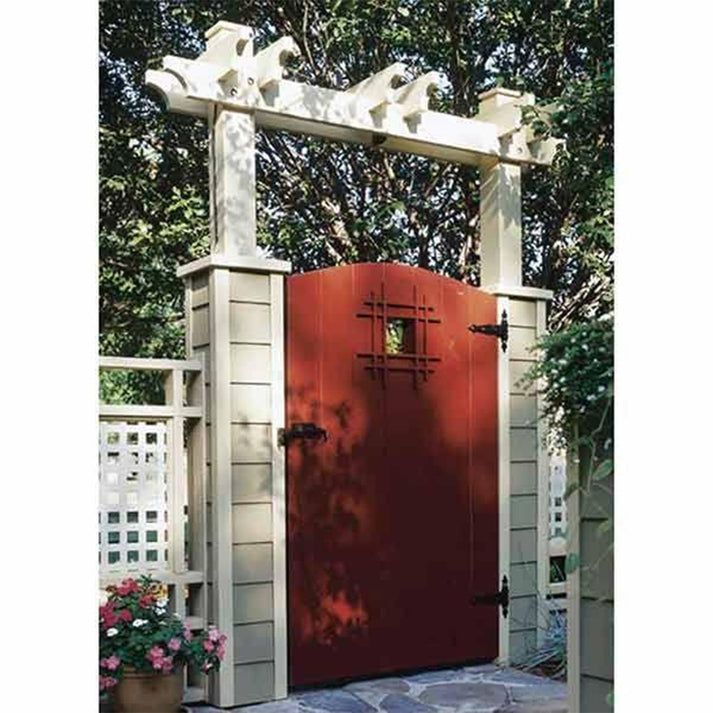 a red door in front of a white fence