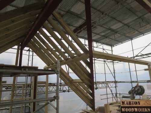 the inside of a building that is being constructed with wood beams and scaffolding