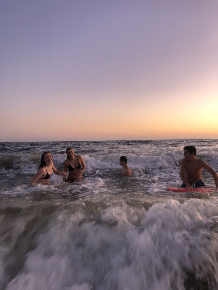 some people are in the water and one is on a surfboard