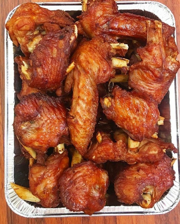 some chicken wings are in a tin on a table