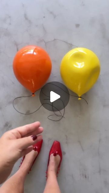 someone is painting three balloons on the floor