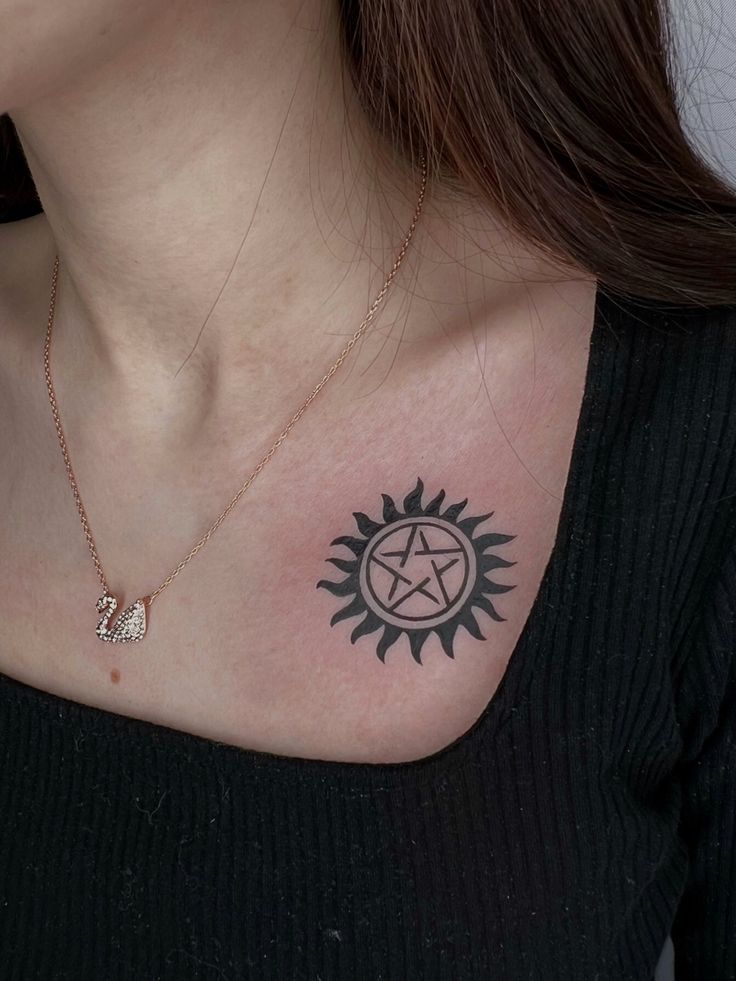 a woman's chest with a pentagramil tattoo on it and a star in the middle