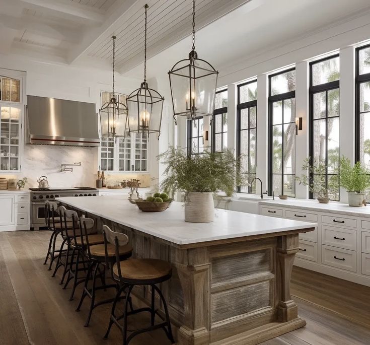 a large kitchen with an island in the middle and lots of windows on both sides