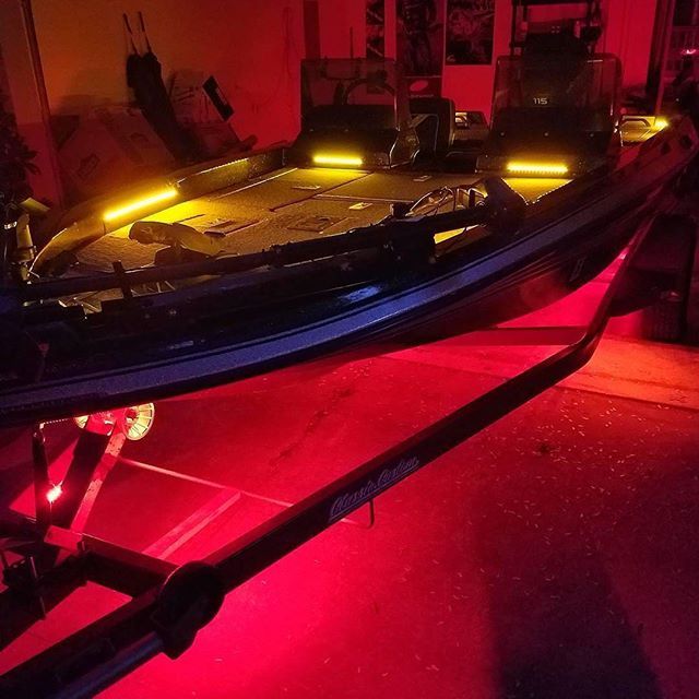 a boat that is sitting on the ground with its lights on and it's front end